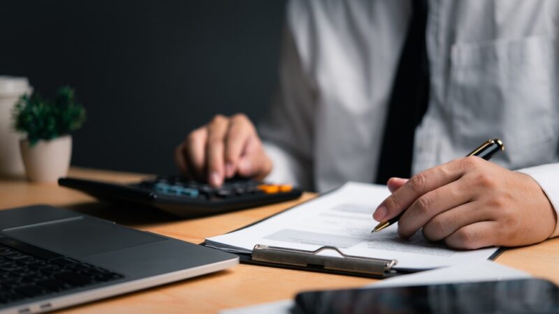 "Antreprenor analizează date financiare pentru a înțelege impactul noilor reglementări fiscale privind impozitul pe 30% din profit în 2025."